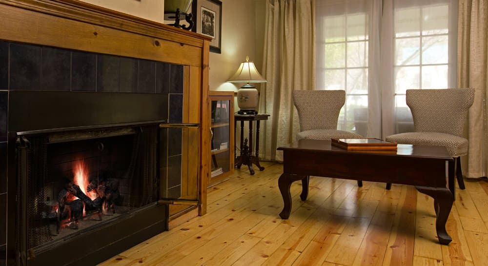 Cozy living room featuring a fireplace, two armchairs, and a wooden coffee table.