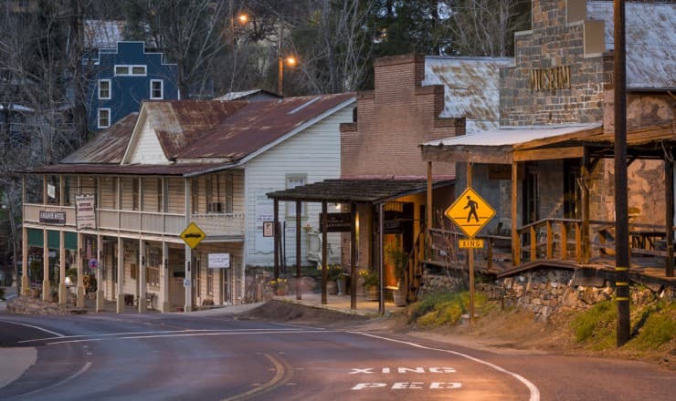 A winding road lined with historic, rustic buildings in a small town.