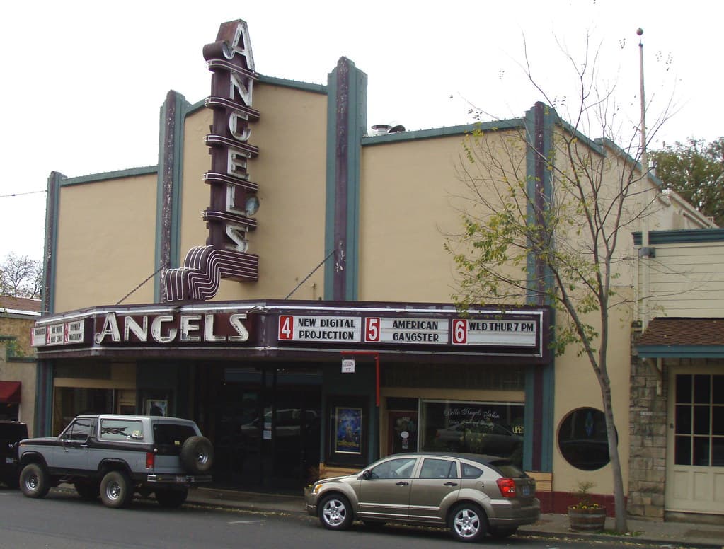 A vintage movie theater called "Angels" with a marquee displaying current films and showtimes.