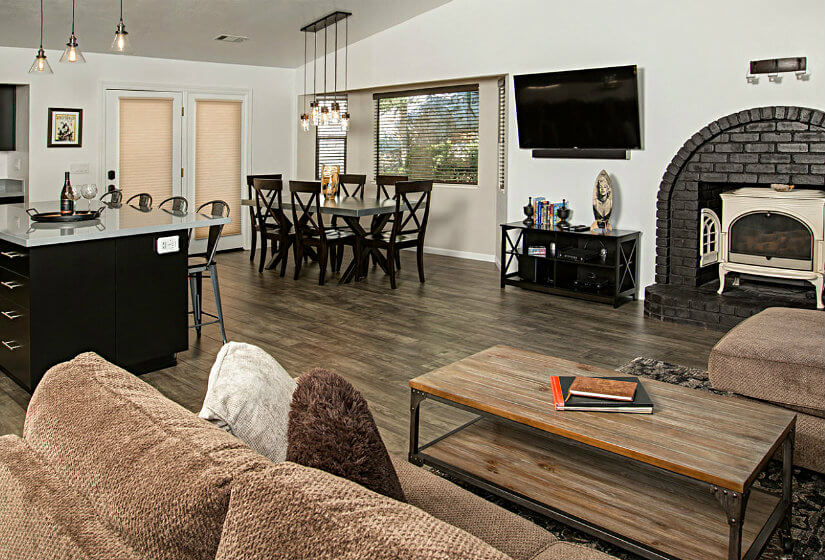 Large room with kitchenette, fireplace, and overstuffed brown furniture